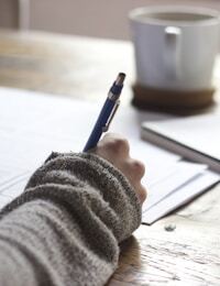 Laptop and notes on a desk — small consistent steps for money habits