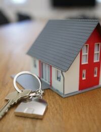 House model and keys on a desk — assets versus liabilities